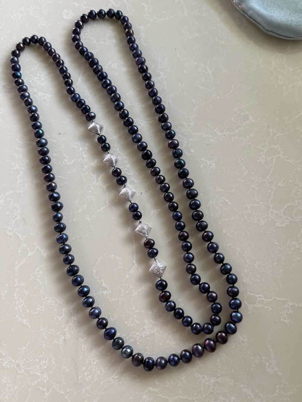 Exceptional 50” necklace of luminous dark blue pearls with sterling silver beads